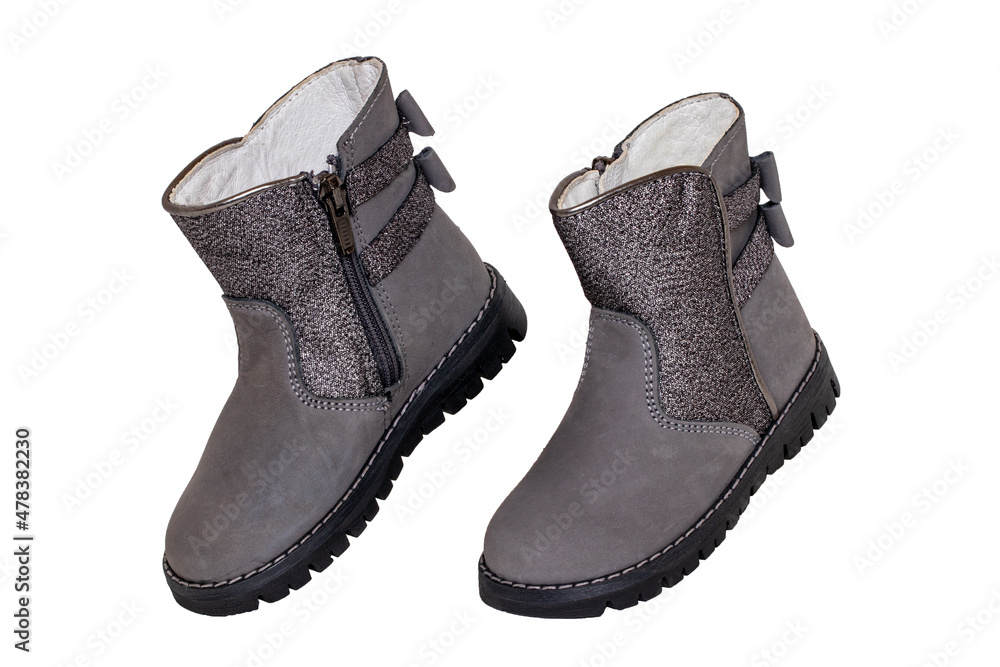 Winter boots. Close-up of a pair elegant gray silver leather winter boots lined with white leather. Girls winter shoe fashion new trends isolated on a white background. Macro photograph. Winter boots. Close-up of a pair elegant gray silver leather winter boots lined with white leather. Girls winter shoe fashion new trends isolated on a white background. Macro photograph.