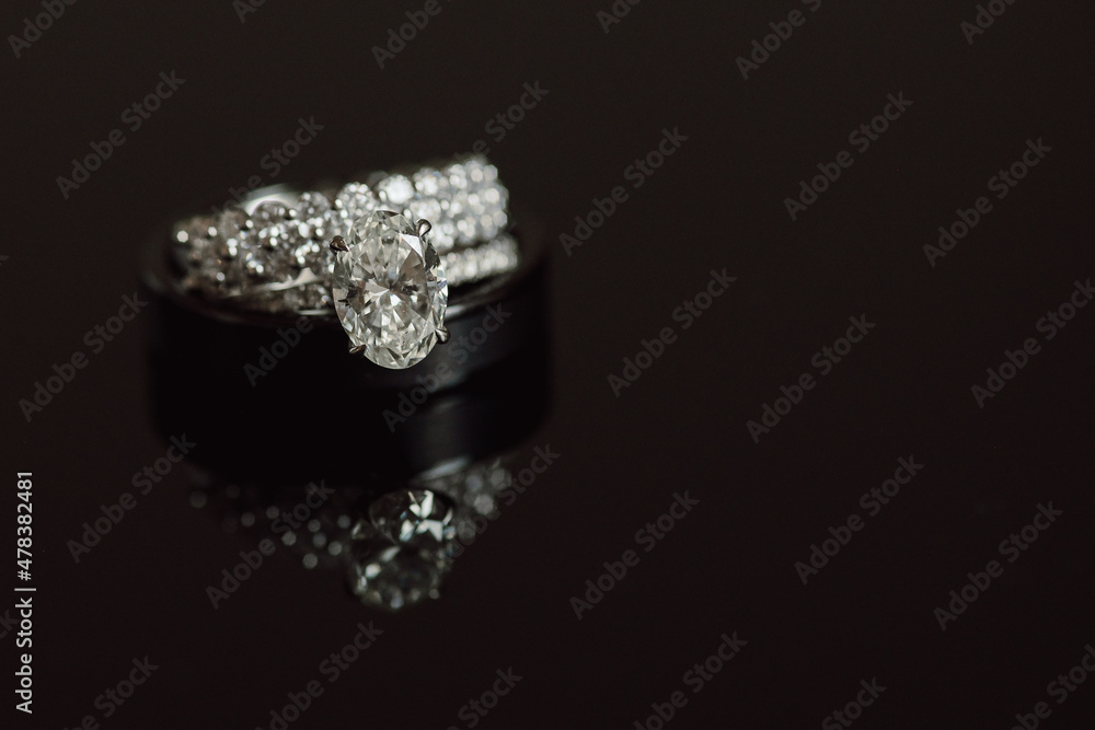 Large Diamond Engagement Ring with Wedding Bands on Dark Reflective Background Large Diamond Engagement Ring with Wedding Bands on Dark Reflective Background