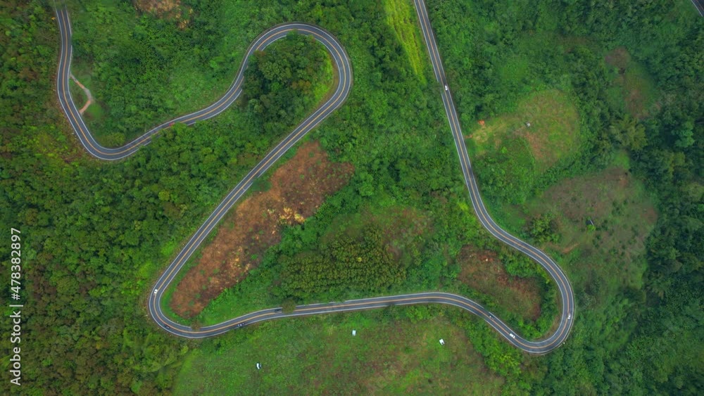 An aerial view of a winding road with cars running in a tropical forest, Thailand.
An aerial view of a winding road with cars running in a tropical forest, Thailand.