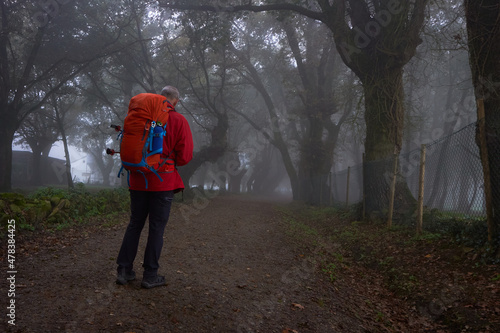 Man on his back walking along a track in foggy weather