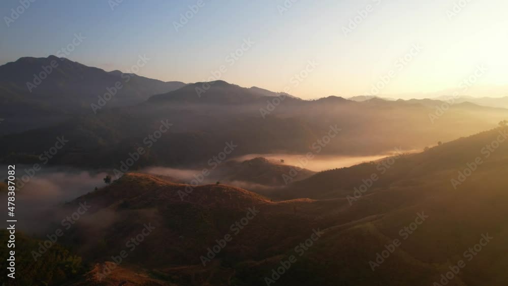 Aerial view of sunrise with fog above mountains
