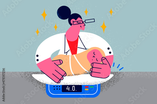 Caring nurse weigh newborn baby in clinic 