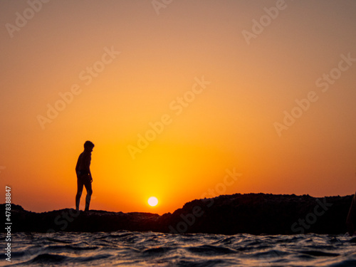 tramonto sul mare sagoma di un ragazzo 638