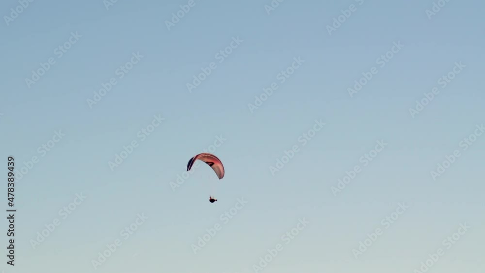 Alone paraglider flying high against the clear blue sky. Paragliding in the sky on a sunny day, extreme sports Alone paraglider flying high against the clear blue sky. Paragliding in the sky on a sunny day, extreme sports