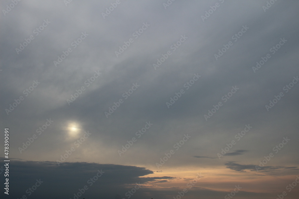 Obraz premium Bewölkter Sonnenuntergang mit dunkelgrauen Wolken.