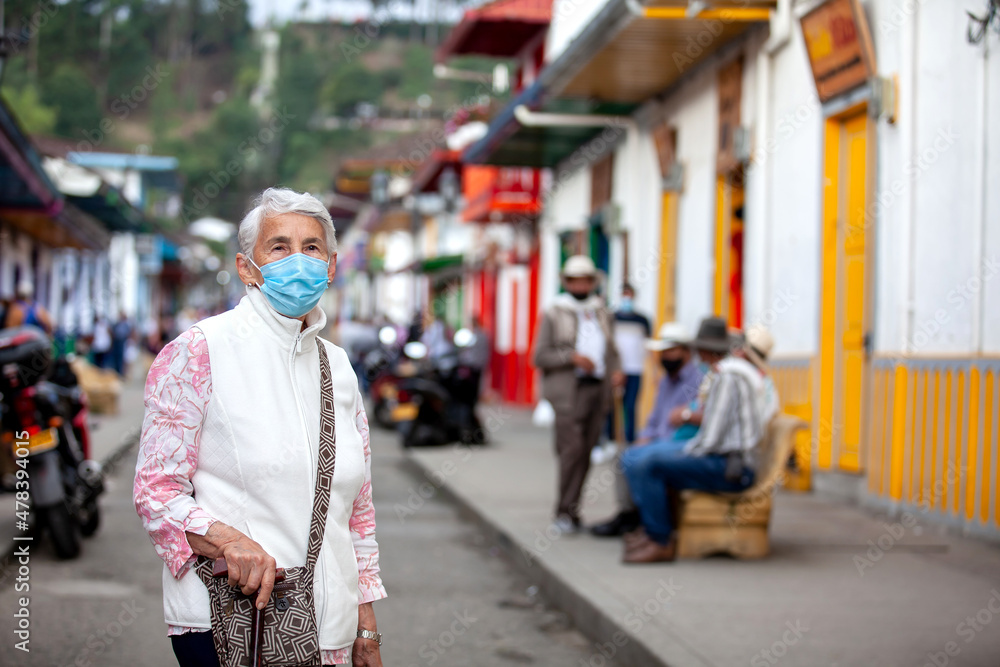Senior woman at a traditional colorful street in the beautiful colonial town of Salento in the region of Quindio in Colombia