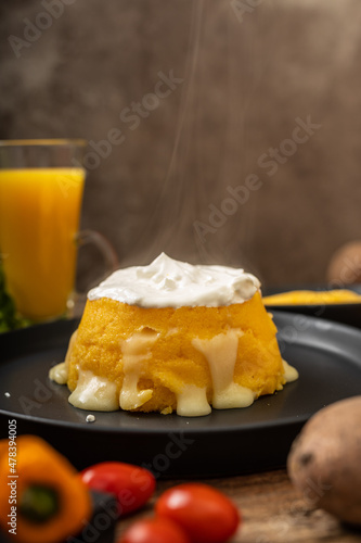 Vegetarian steaming maize with sour cream and melted cheese