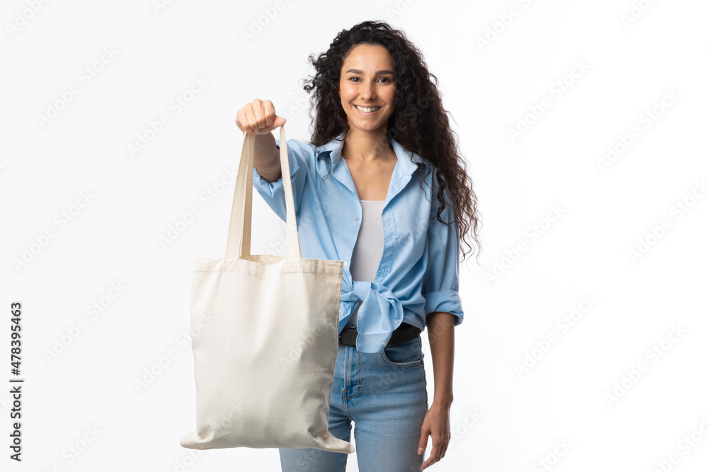 Millennial Woman Showing White Eco Bag To Camera, White Background Millennial Woman Showing White Eco Bag To Camera, White Background