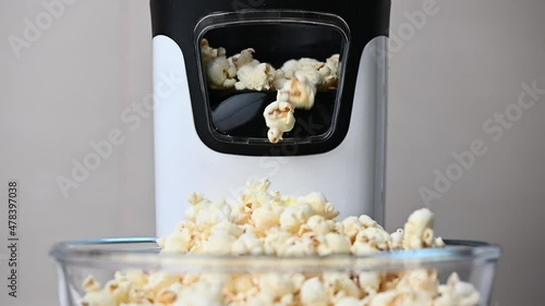 Slow motion video of popcorn machine producing popcorn out into bowl photo