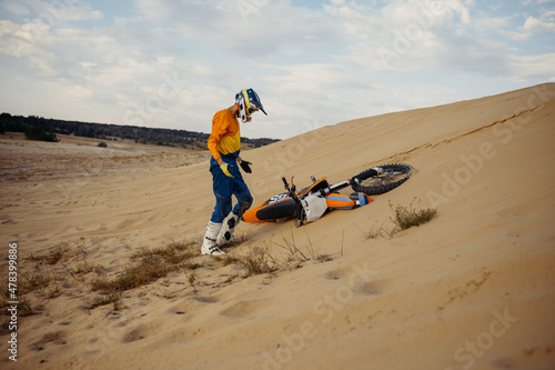 Motocross rider in helmet picks up scooter