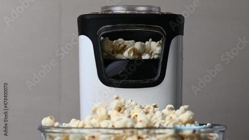 Slow motion 4K video of popcorn machine producing popcorn out into bowl photo
