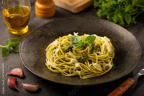 Pasta spaghetti with pesto sauce and basil leaf.