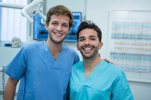 Two young fellow dentists smiling in the dental clinic