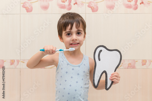 Wallpaper Mural A little boy is brushing his teeth, holding a cardboard tooth in his hands. Oral hygiene. Torontodigital.ca