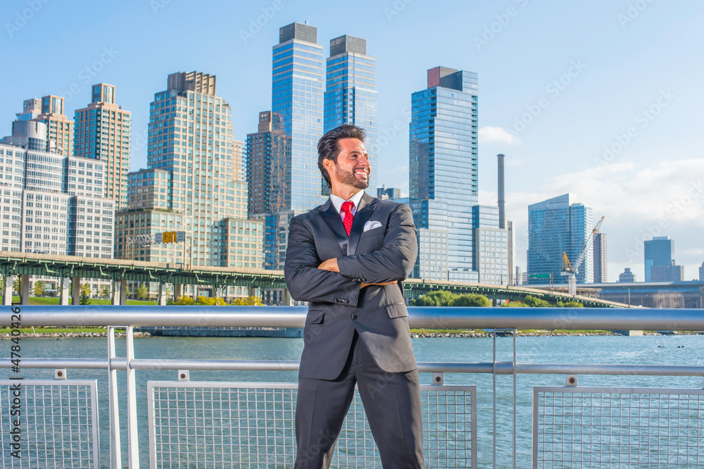 Dressing is a black suit, a red tie, crossing arms, a sexy, middle age businessman with mustache and beard is standing in the front of a business district, confidently looking forward.. Dressing is a black suit, a red tie, crossing arms, a sexy, middle age businessman with mustache and beard is standing in the front of a business district, confidently looking forward..
