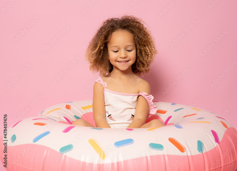 kid summer. Little girl in swimsuit, sitting on inflatable ring. Concept of vacation, beach, sea. kid summer. Little girl in swimsuit, sitting on inflatable ring. Concept of vacation, beach, sea.