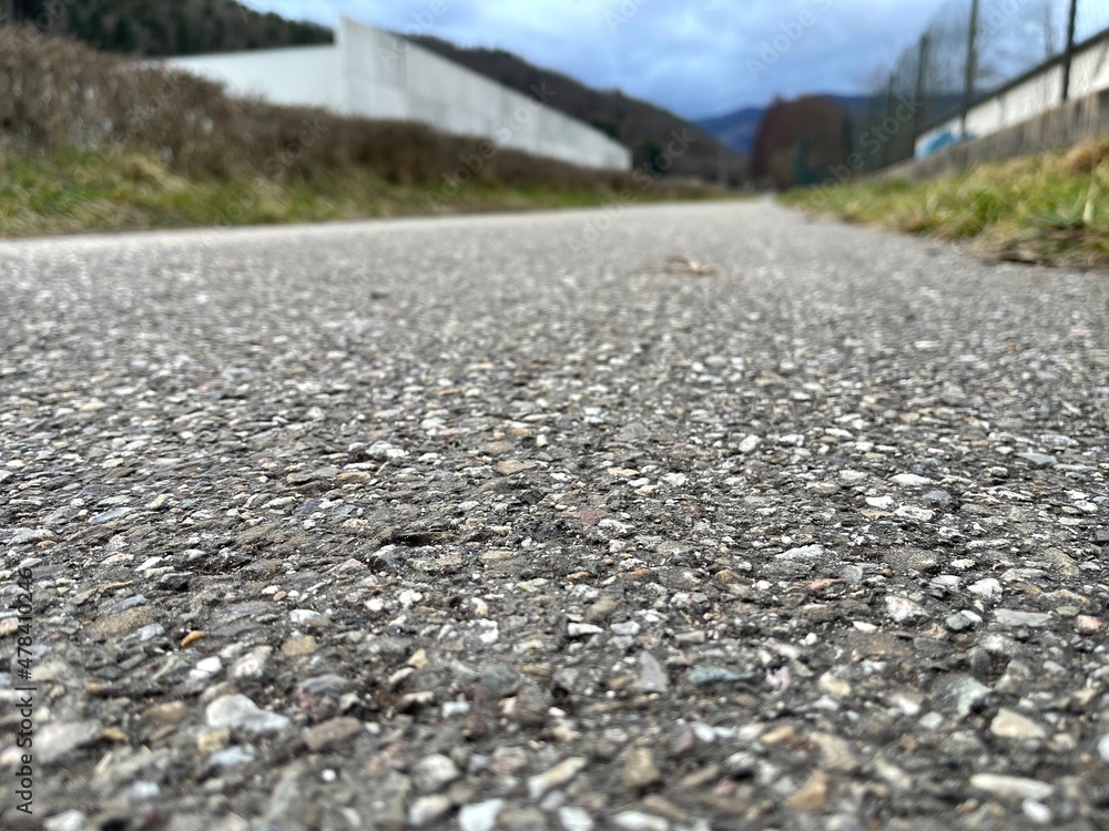 Cycle path or small road, in asphalt, photographed at ground level, blurred background Cycle path or small road, in asphalt, photographed at ground level, blurred background