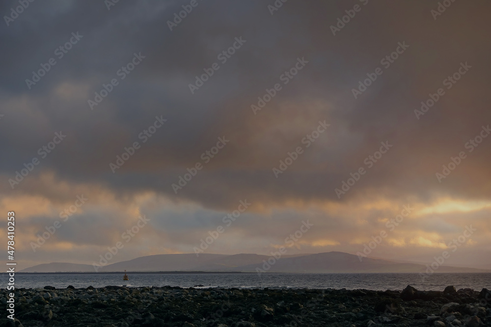 Dramatic cloudy sky with sun beam over calm ocean surface. Peaceful and calm atmosphere Dramatic cloudy sky with sun beam over calm ocean surface. Peaceful and calm atmosphere