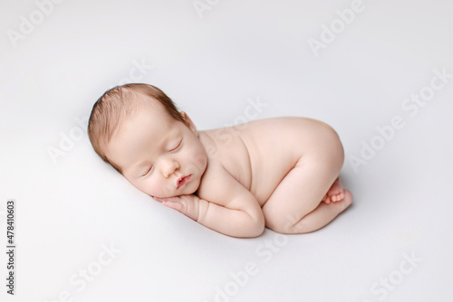  Newborn girl on a white background. Photoshoot for the newborn. A portrait of a beautiful sleeping newborn baby girl