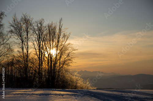 a winter mountain glade in the background the setting sun, mountain mood, Beskid Sądecki