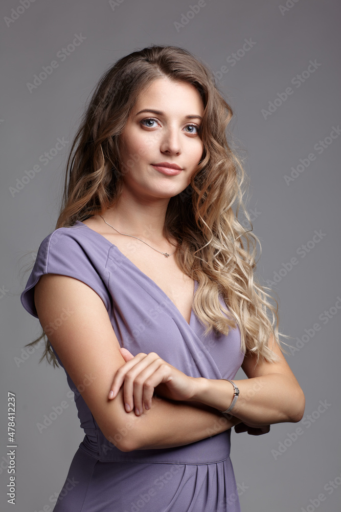 Obraz premium Studio beauty portrait of a young woman in a summer dress with hands crossed.