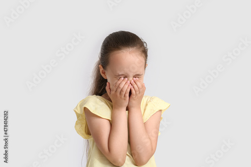 Little girl crying on white...