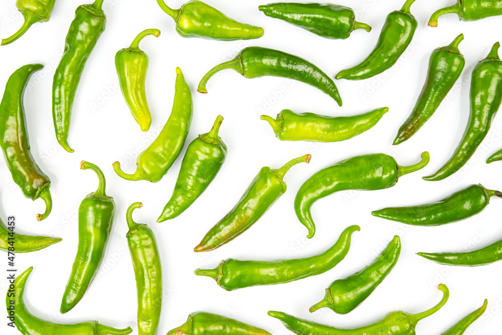 green hot peppers evenly spread on a white background. vitamin vegetables for health green hot peppers evenly spread on a white background. vitamin vegetables for health