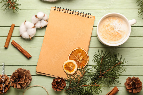 Composition with notebook, cup of cacao and natural decor on color wooden background. Hello winter