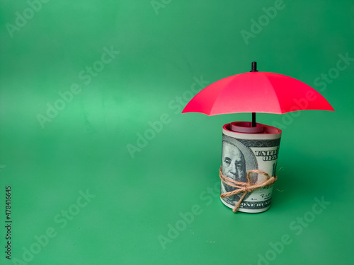 Copy and text space.Red umbrellas protect the banknotes, save families, prevent risk and the concept of insurance.