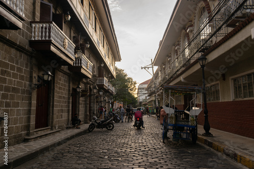 Walking along the street of an old city during sunset. Intramuros, Manila, Philippines photo