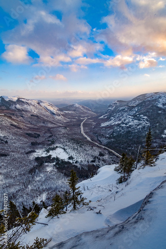 Classic winter landscape. The snowy valley and its sinuous road seen from Dome mountain at dusk, Quebec, Canada