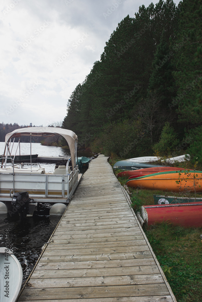 Fototapeta premium Boat dock by the lake with canoes on the lake bank