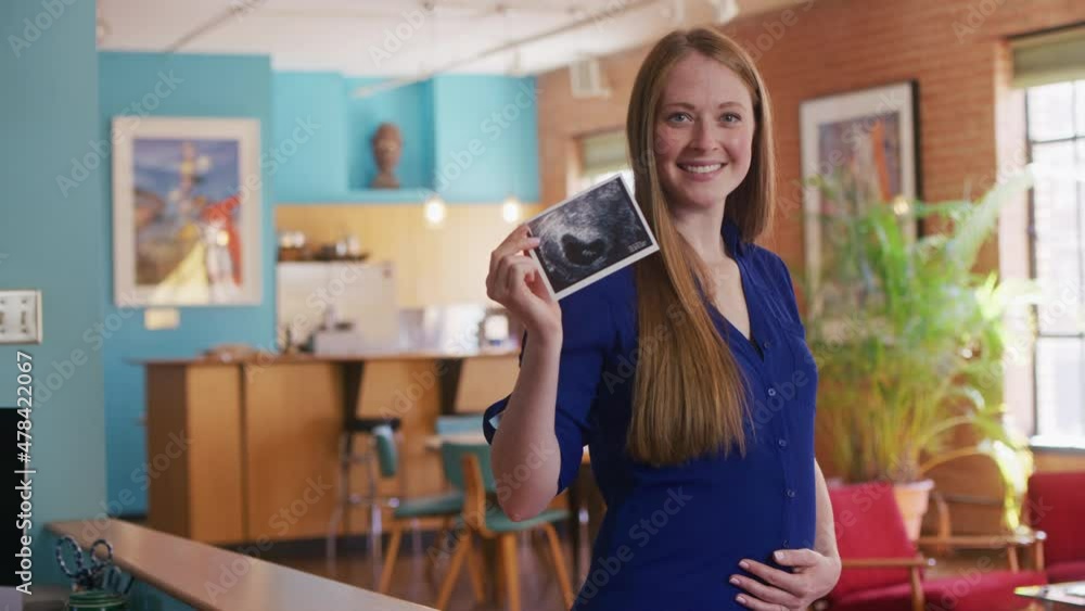 Portrait of a pregnant mother holding an ultrasounds looking into camera. Portrait of a pregnant mother holding an ultrasounds looking into camera.