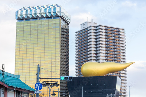 business buildings with golden unique shape object at crossroad in front of azumabashi in asakusa, tokyo