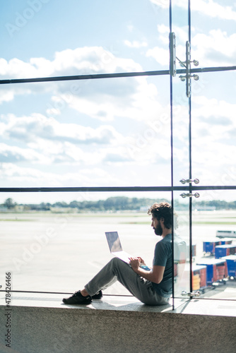 person sitting alone in an empty airport © Leslie Rodriguez