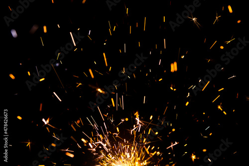 Fotografia Sparks from firework in front of black backgound