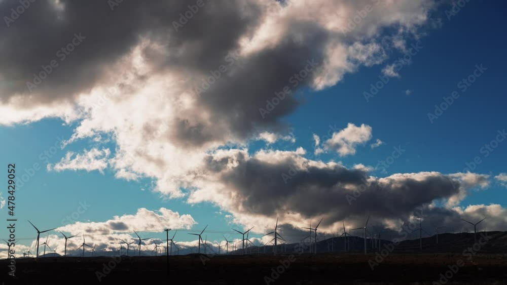 The wind blows through a wind farm in the Mojave Desert generating clean energy on a cloudy day - static wide angle scenic view The wind blows through a wind farm in the Mojave Desert generating clean energy on a cloudy day - static wide angle scenic view