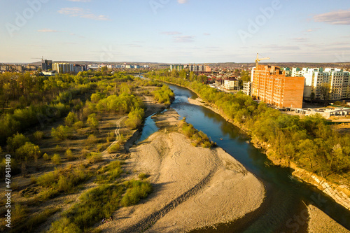 Aerial view of tall residential apartment buildings under construction and Bystrytsia river in Ivano-Frankivsk city, Ukraine.