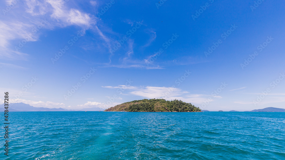 Island under blue sky in blue sea