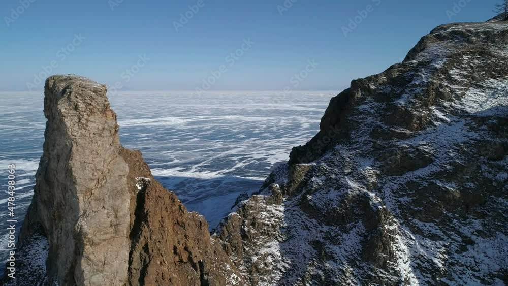 Aerial orbital shot of cape Khoboy, Olkhon island. Tall rocks in frozen lake Baikal. Popular touristic destination. Winter landscape. Panoramic view Aerial orbital shot of cape Khoboy, Olkhon island. Tall rocks in frozen lake Baikal. Popular touristic destination. Winter landscape. Panoramic view