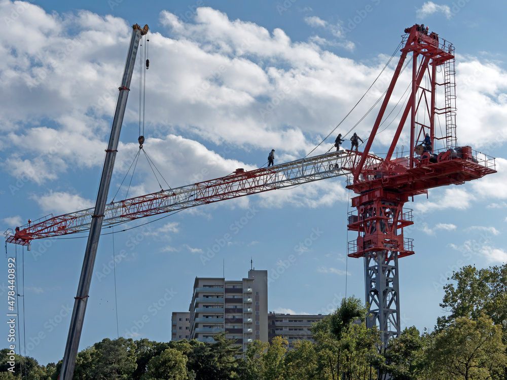 Tokyo,Japan - October 25, 2021: Assembly of a tower crane. Connecting a jib with the tower.
