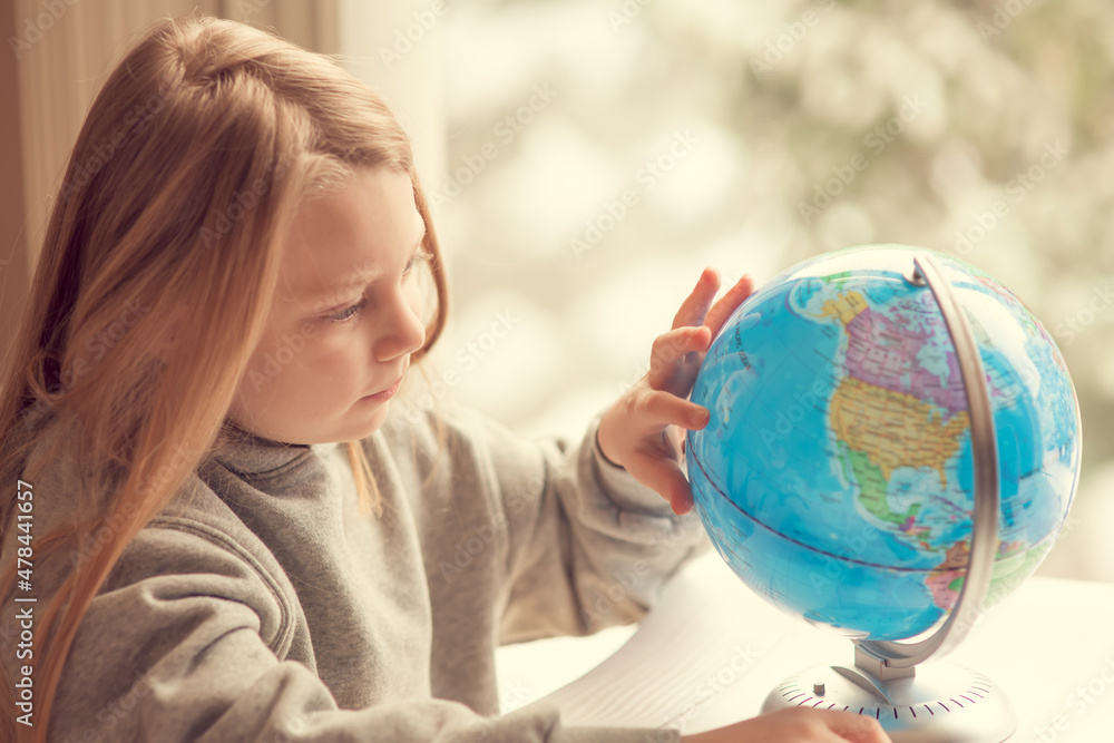 Little girl with a globe, child studying, homeschooling Little girl with a globe, child studying, homeschooling