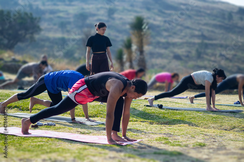 group of people doing plank pose, outdoor yoga group practice, exercise on mountain esplanade. Healthy health
