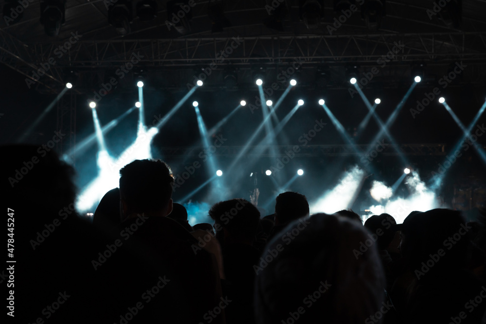 Concert background. Stage with spotlights and silhouette of people.