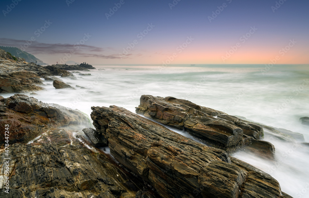 waves and rocks in sunrise in long exposure