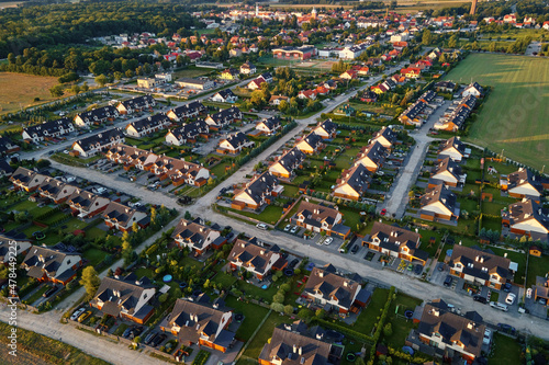 Fototapeta Naklejka Na Ścianę i Meble -  Aerial view of suburban neighborhood, Residential district with buildings and streets at small european town at sunset