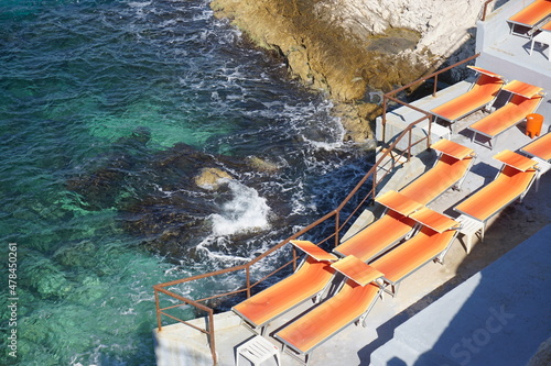 view of the sea and colorful lounge chairs in the rocky calanque marseille france