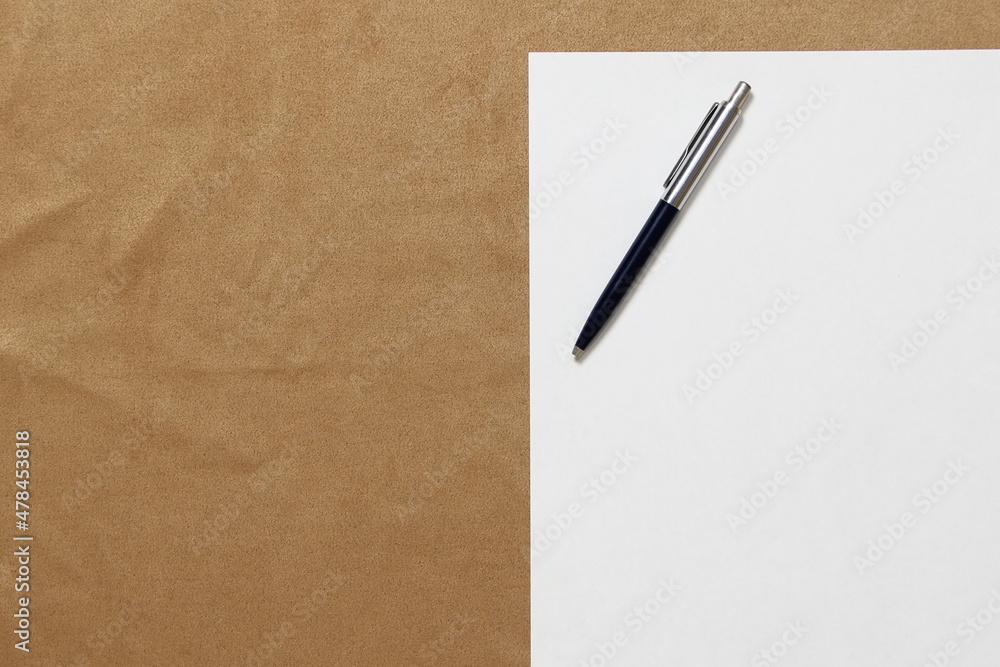 Template of white paper with pen lies on light brown cloth background. Concept of business plan and strategy. Stock photo with empty space for text and design. Template of white paper with pen lies on light brown cloth background. Concept of business plan and strategy. Stock photo with empty space for text and design.