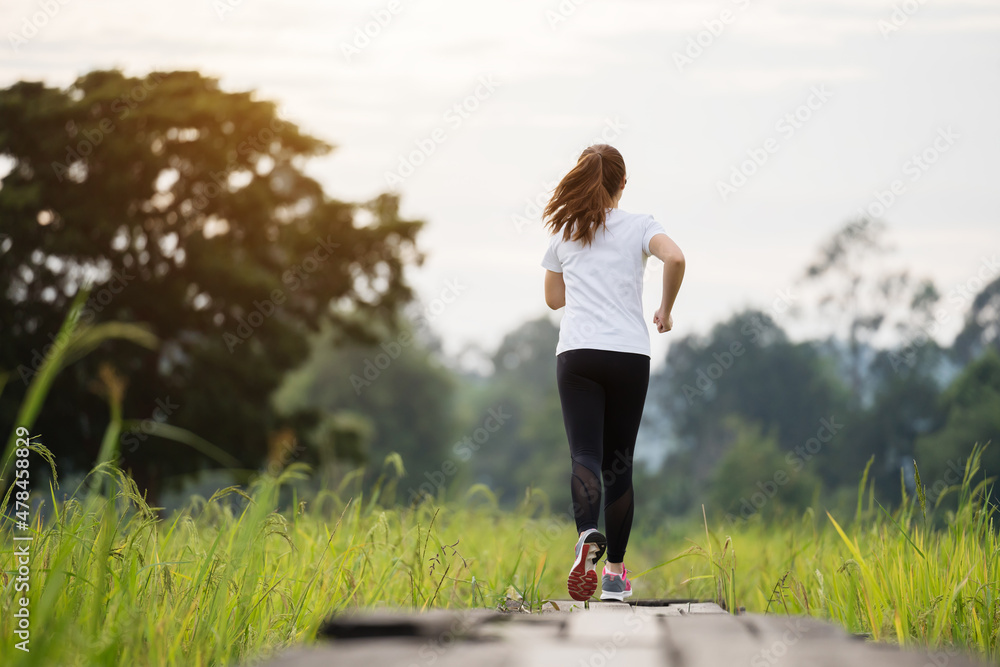 woman running on wooden path in field woman running on wooden path in field