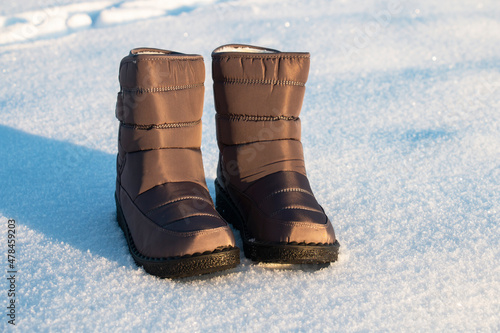 winter puffy women's boots for walking in the snow in frost photo